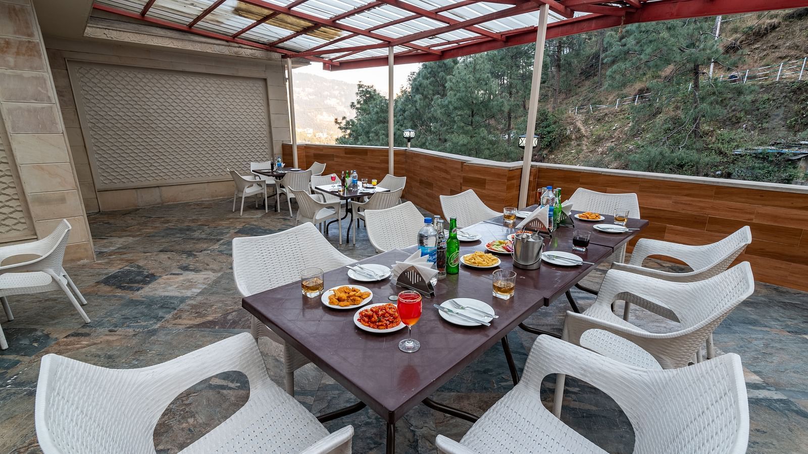 A terrace with a dining setup, featuring a sheet-covered top and offering stunning mountain views at DLS Hotels The Rock Castle.